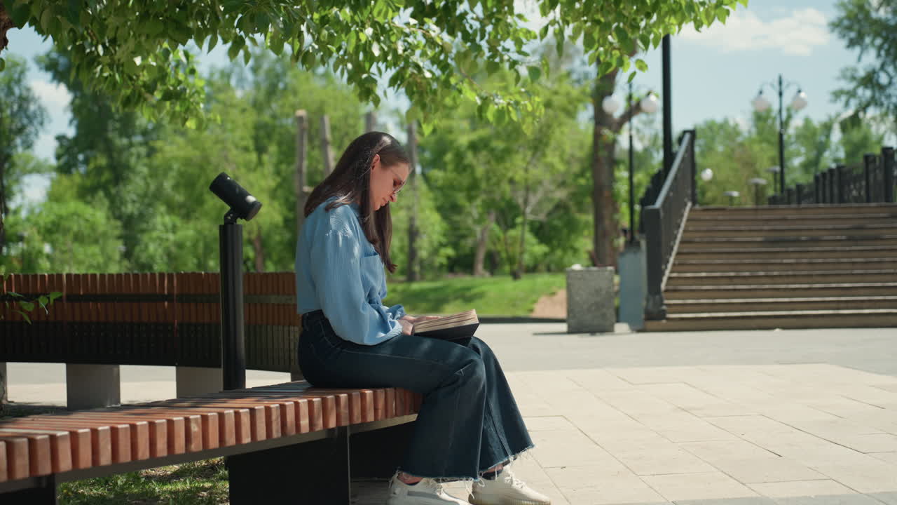 디자인에 몰두한 도시 여성, 데님을 입은 젊은 여성이 야외에서 평화롭게 건축 도면을 검토하고, 편안한 여학생이 도시 캠퍼스 벤치에서 차분하게 건축 스케치를 검토하고 있어요