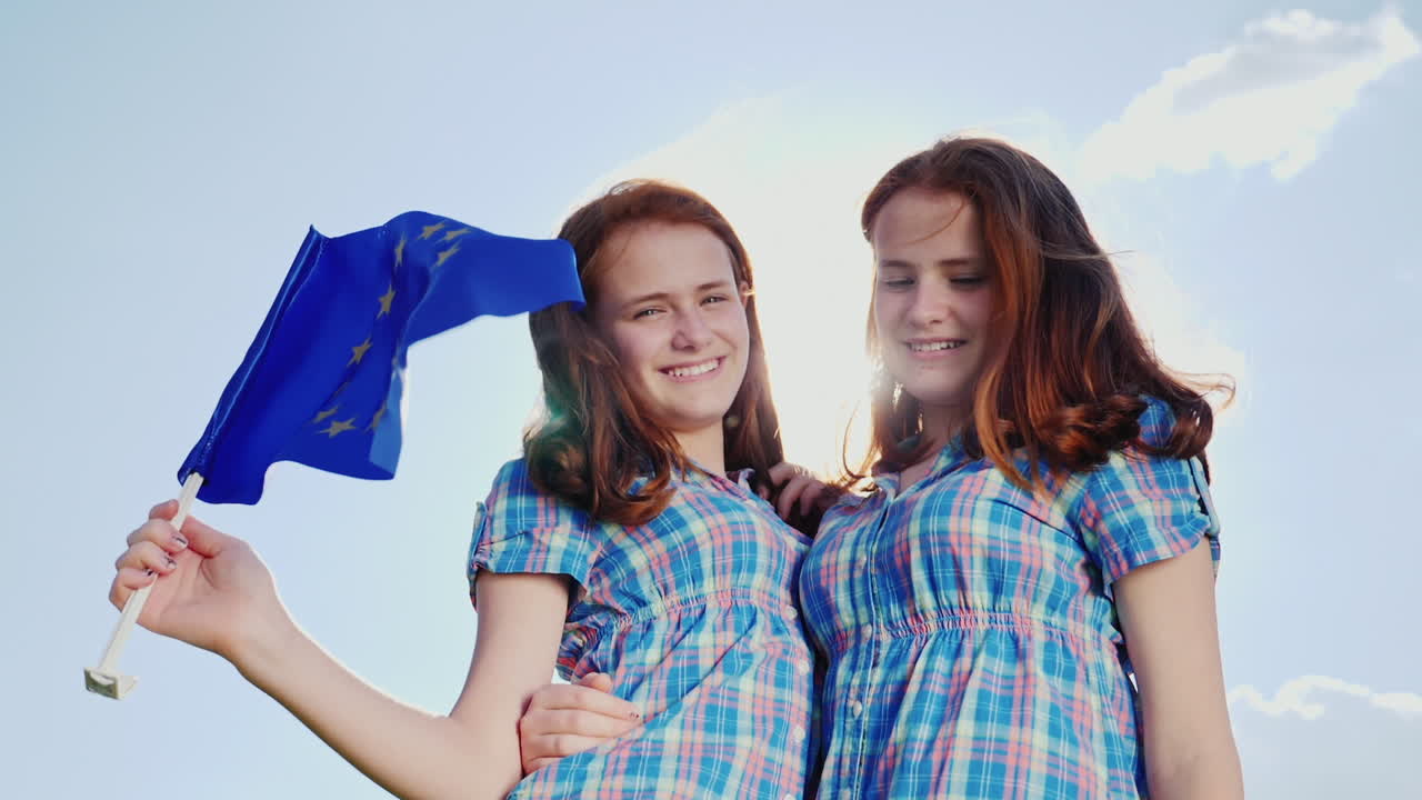 유럽 연합의 국기와 함께 두 쌍둥이 자매