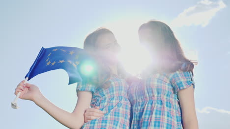 Two-Twin-Sisters-With-The-Flag-Of-The-European-Union