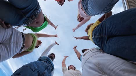 diverse group of young adults celebrating together with hands in unity
