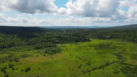 a beautiful drone shot of the mountainous plains in new england with a couple patches of marshland