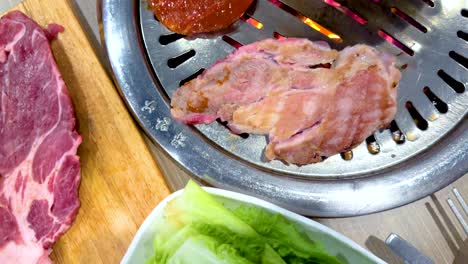 slices of meat grilling on a bbq with vibrant side dishes. warm lighting enhances the culinary experience