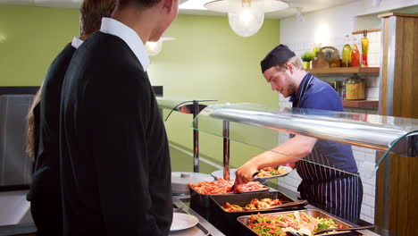 teenage students being served meal in school canteen