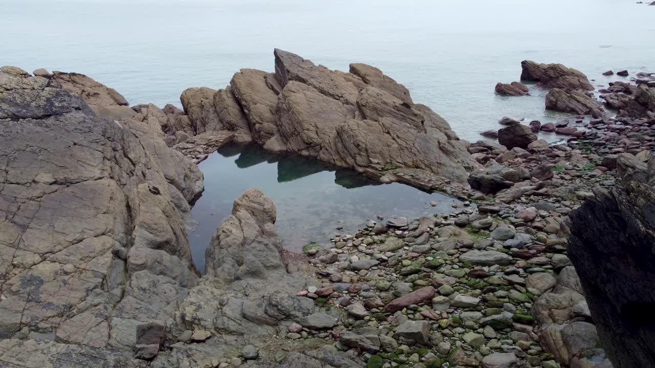 drone aéreo 4k de la piscina de rocas junto al mar en woody bay north devon reino unido