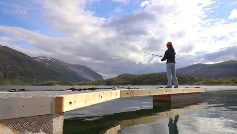 woman fishing on fishing rod spinning in norway.