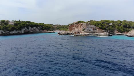 Aerial-drone-shot-over-a-sea-entrance-of-Mallorca-island-beach-Spain