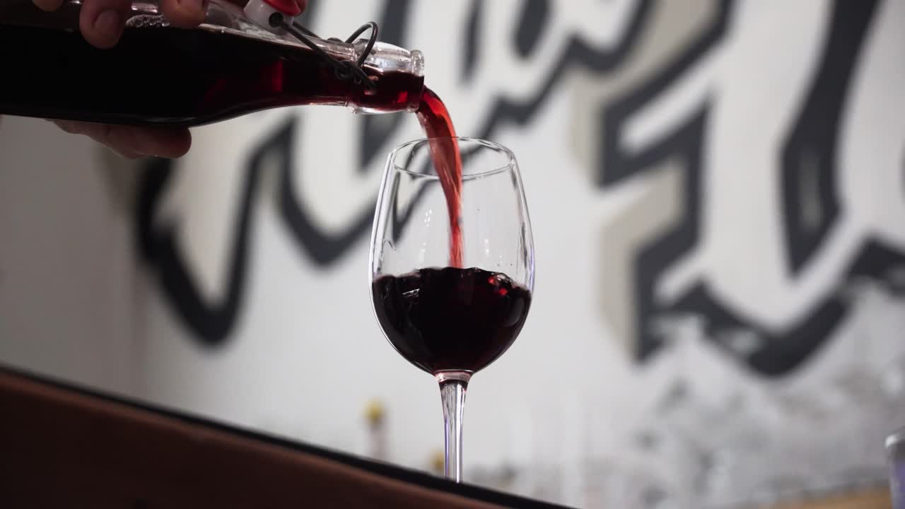 Person Pouring Red Wine In A Glass At The Bar Counter In Sydney, Australia. Close-up Shot