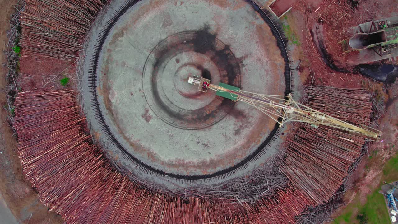 vista aérea de una fábrica de chips en brent, alabama, que muestra grandes pilas de madera listas para el procesamiento y una grúa en funcionamiento