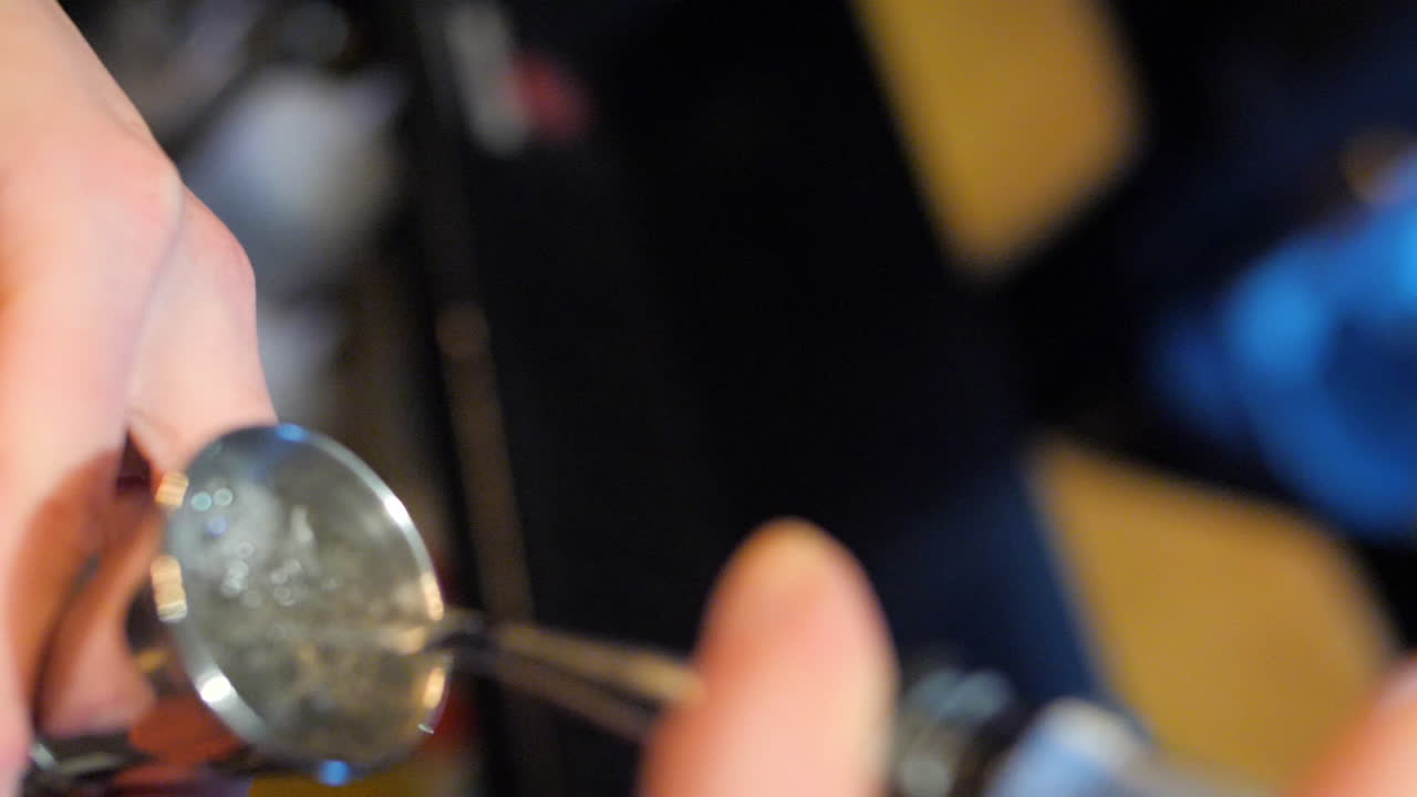 verter vodka en jigger en cámara lenta con poca profundidad de campo, primer plano