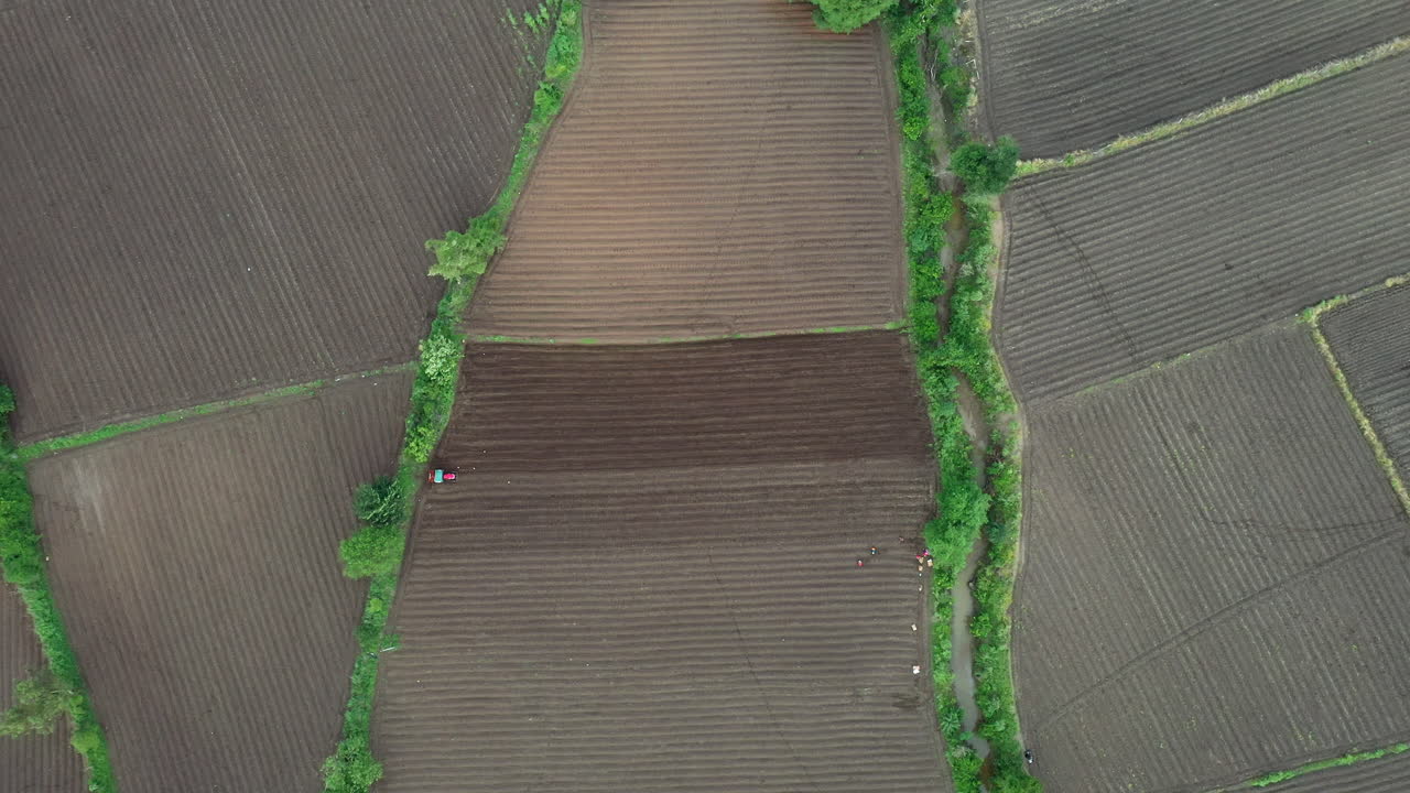 Aerial view of farmland with tractor and people