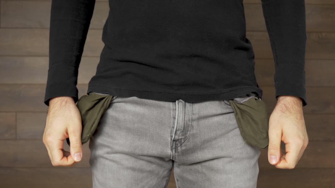 돈이 없는 청바지 차림의 가난한 청년은 빈 주머니, 정적인 샷