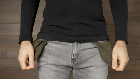 pobre joven en jeans sin dinero se vuelve bolsillos vacíos, tiro estático