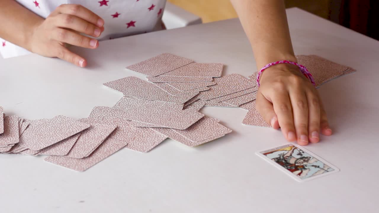 Woman&rsquo;s hands spreading tarot cards, sliding them and picking random one