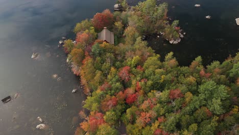 Vista-Aérea-De-La-Casa-Del-Lago-Escondida-En-Un-Bosque-Exuberante-Y-Colorido-En-Colores-Vivos-De-Otoño