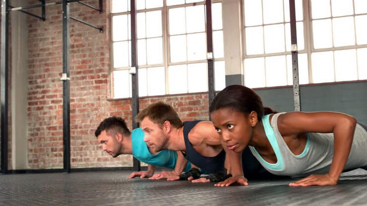 Fit people doing push ups in gym