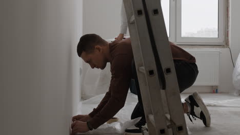 young couple renovating their home: painting and preparing walls