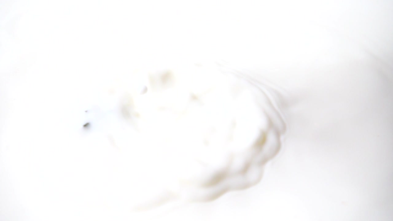 Erdbeere fällt in Milch. Zeitlupe. Aufnahme von Früchten. Zeitlupe.