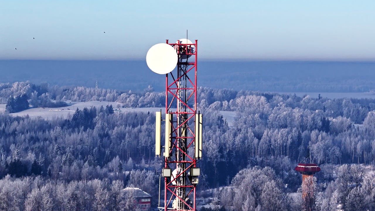 Aerial view of Telecommunication tower providing network signal over a vast frozen winter landscape