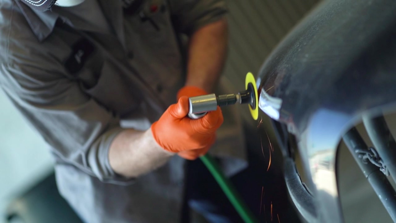 Autobody repair employee working wish mask