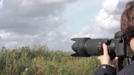 Woman-taking-photos-in-a-rush-field