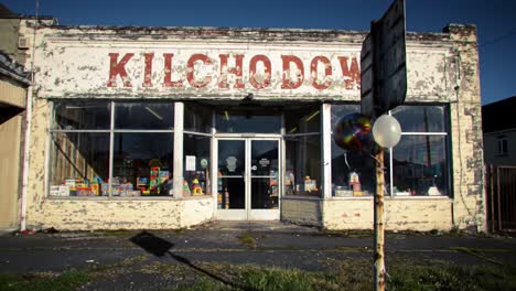 a nostalgic look at an abandoned toy storefront reflecting the passage of time with weathered paint and playful display items inside
