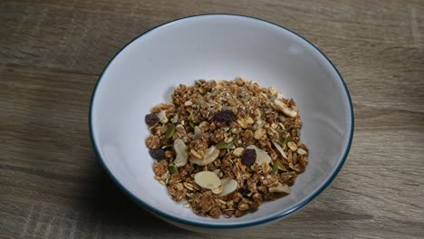 alejar la granola en un bol con semillas, frutas secas, pasas, desayuno saludable perfecto