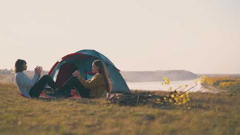 Mädchentouristen-Machen-Bauchmuskelübungen-Und-Klatschen-Im-Lager-Am-Zelt