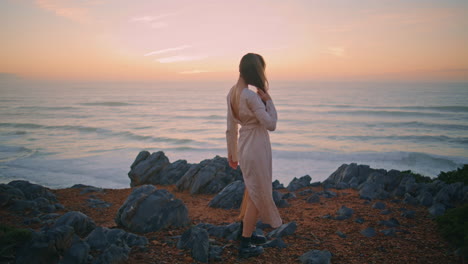 relaxed model walking hill at evening. romantic girl turning around posing alone
