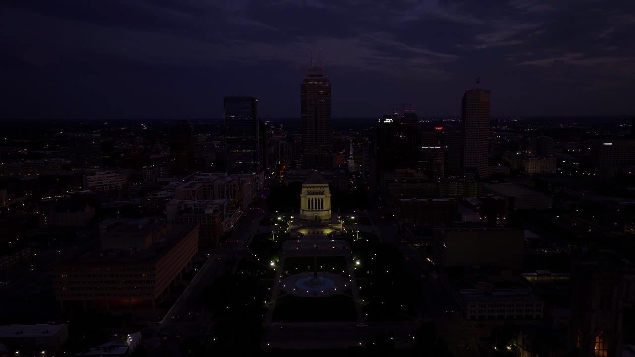 Centered over Indiana World War Memorial plaza at dusk, symmetrical layout, aerial tracking right