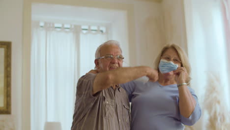 senior couple happily taking off their masks after vaccination