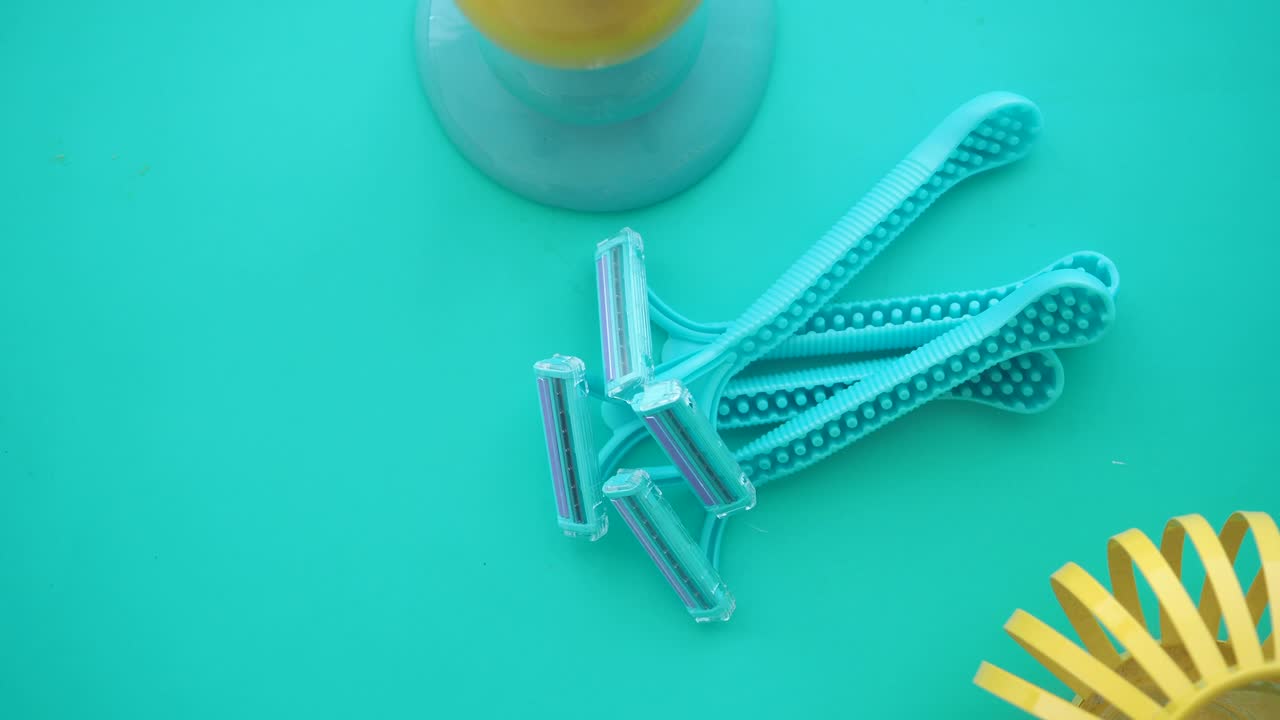 Several disposable razors on a colored surface