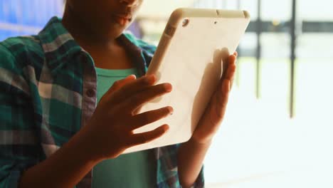 Mathematical-equations-floating-against-boy-using-digital-tablet