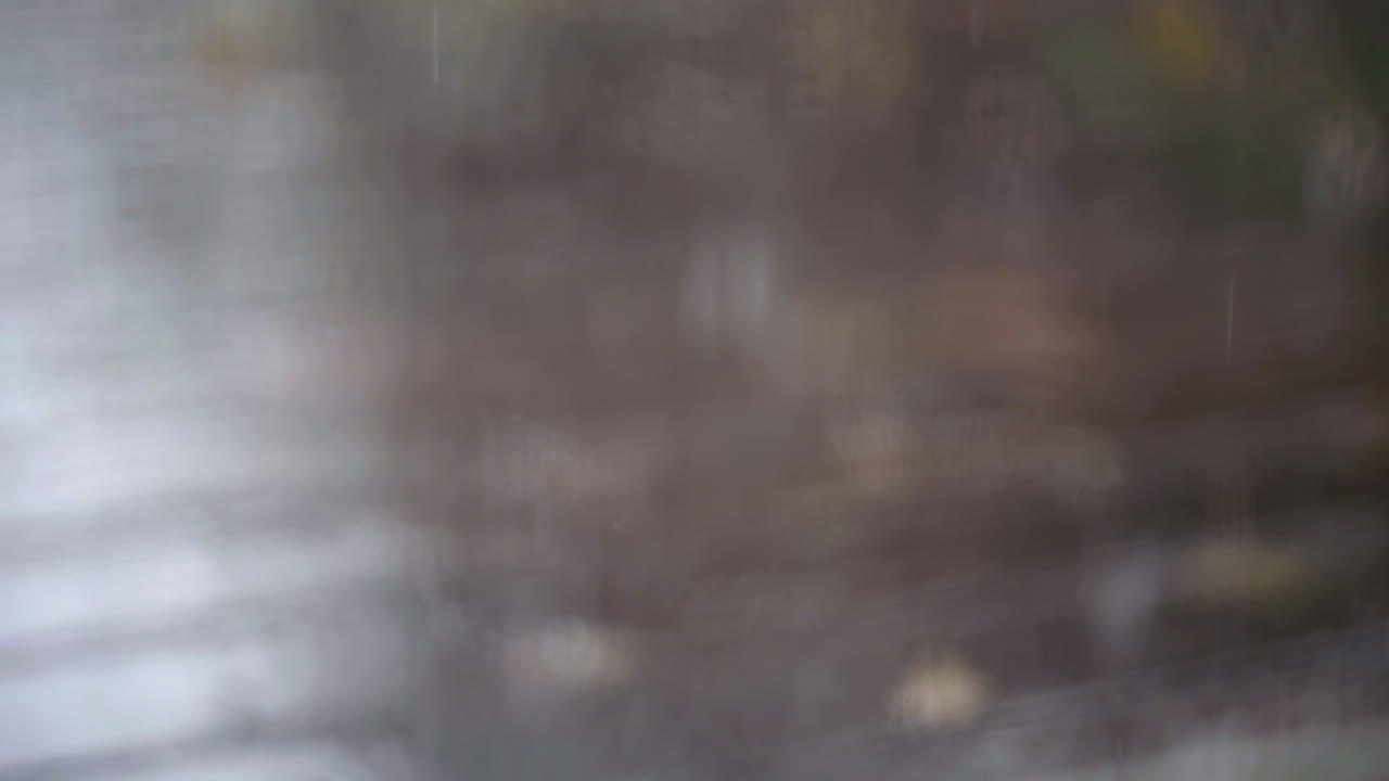 젖은 창에서 나무 데크에 떨어지는 빗방울까지 슬로우 모션 랙 포커스