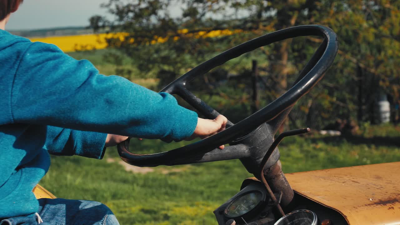 chico en el viejo tractor amarillo, fingiendo estar conduciendo