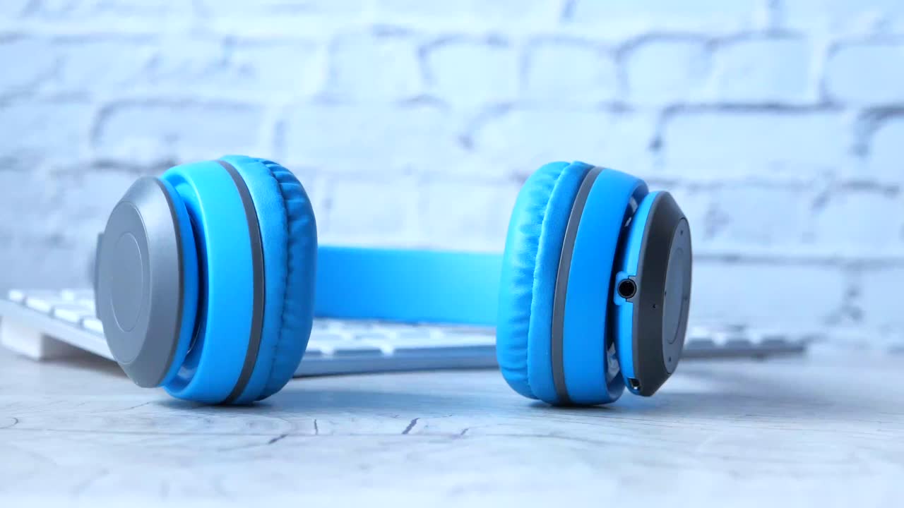 키보드가 있는 책상 위에 파란 헤드폰