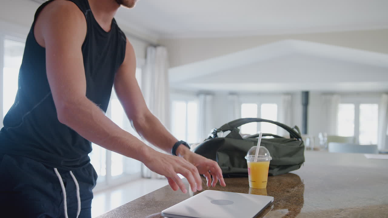 joven descargando datos del rastreador de salud personal al portátil después del ejercicio