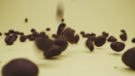 falling and bouncing of coffee beans on yellow background