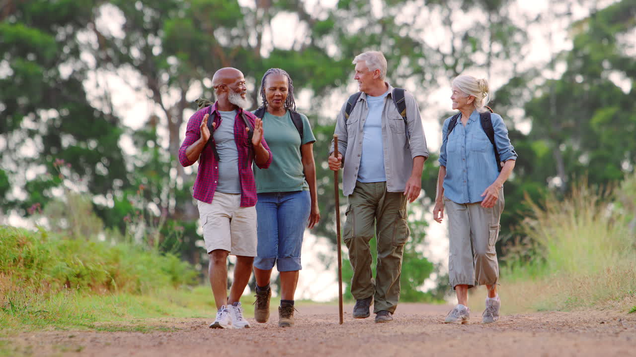 grupo de amigos mayores activos disfrutando de hacer senderismo por el campo caminando juntos por el sendero