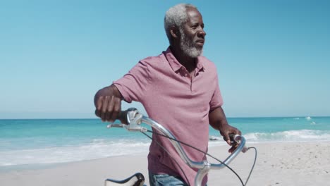 senior man with a bike at the beach