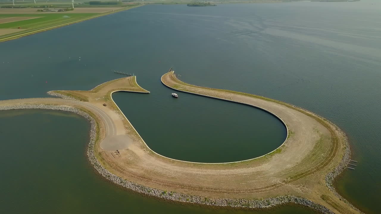 Aerial drone shot over the man made Peninsula Tulip island at the coastline of the Zeewolde, Netherlands.