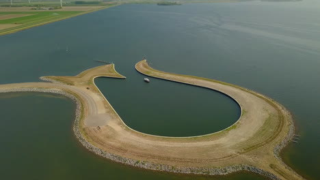 aerial drone shot over the man made peninsula tulip island at the coastline of the zeewolde, netherlands.