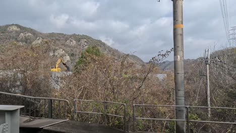 passing landscape with mountains, vegetation, and construction.