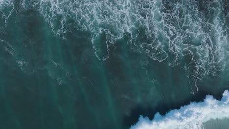 Top-Down-Slow-Motion-Drone-shot-of-abstract-wave-motion-and-patterns-in-Uluwatu-Bali-Indonesia