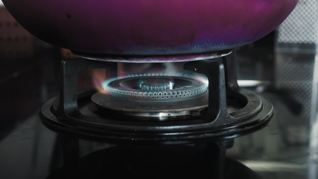 부에서 파란색과 빨간색으로 불타는 불꽃이 있는 검은색 가스 스토브의 비디오