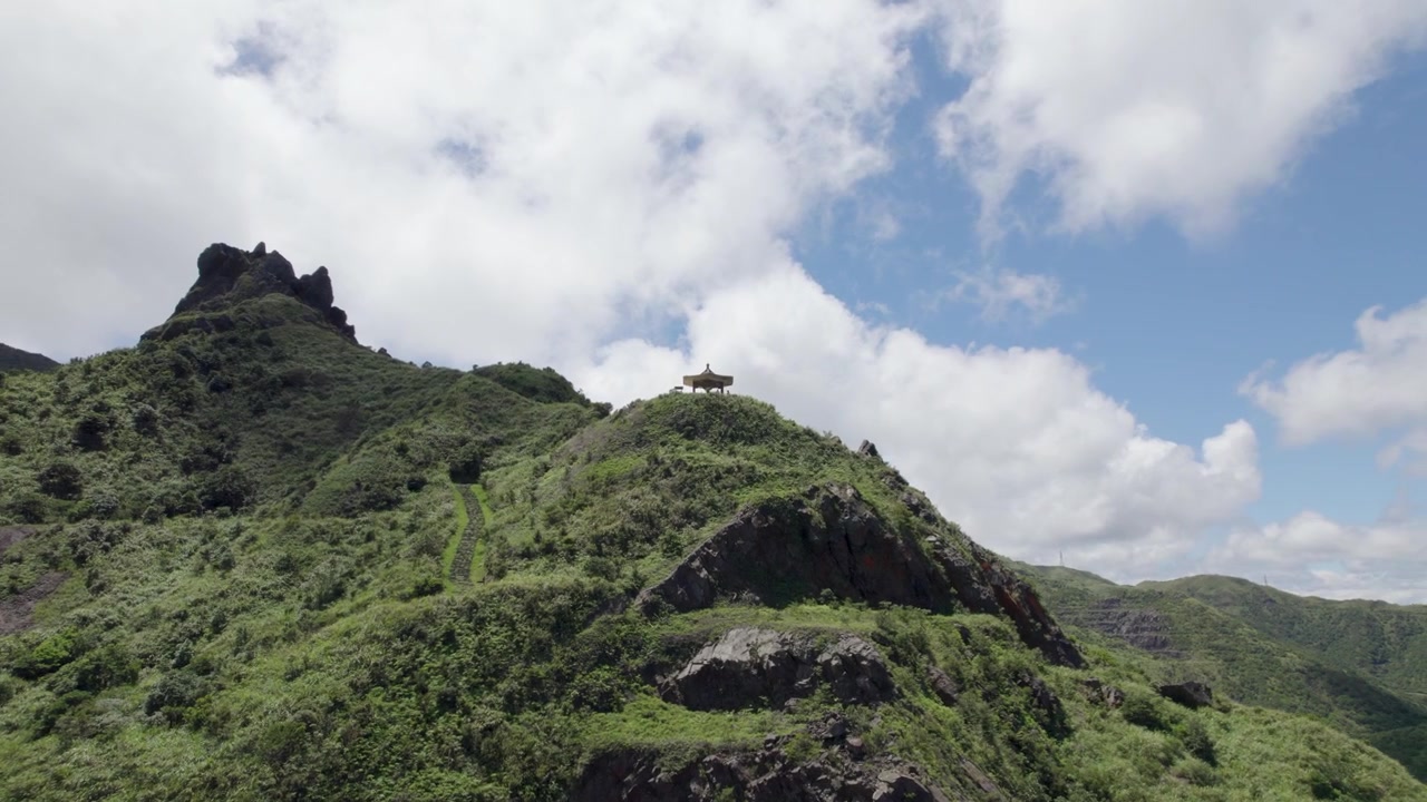 Veduta aerea del Monte Teapot nel distretto di Ruifang, Taiwan, incentrata su un padiglione tradizionale asiatico con le scogliere della montagna sullo sfondo. Una famosa destinazione escursionistica sulla costa orientale di Taiwan