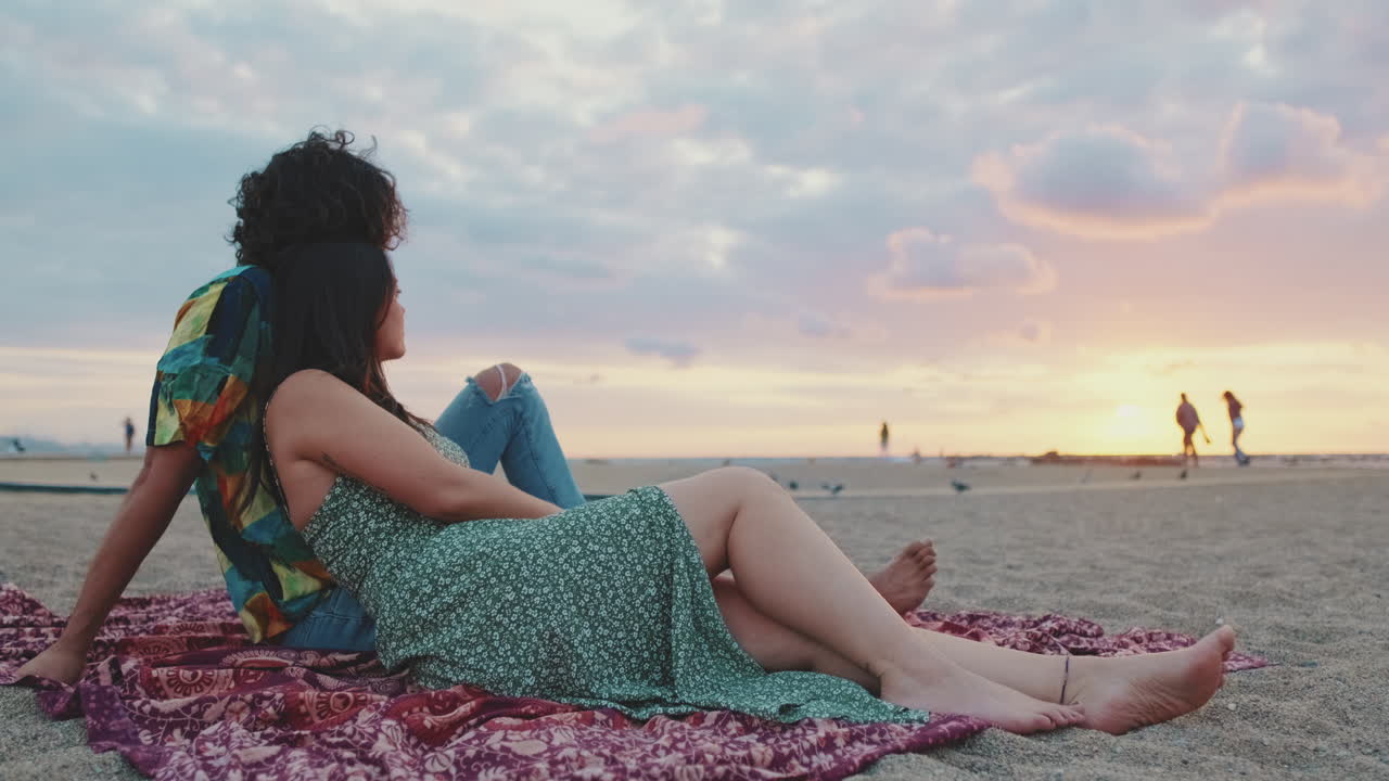 Couple Relaxing on the Beach at Sunset