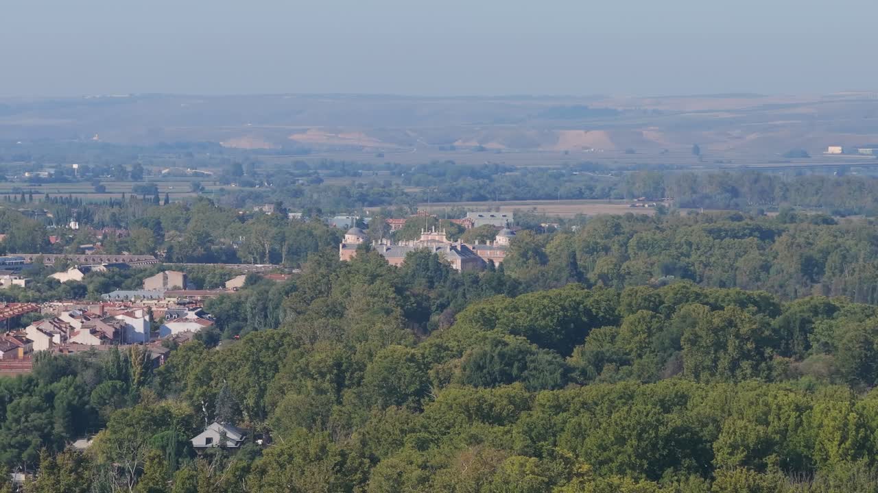 Drone flight and with a turn we discover the domes of the royal palace and many treetops in its gardens, we continue seeing part of the town, in the background we have plateau mountains