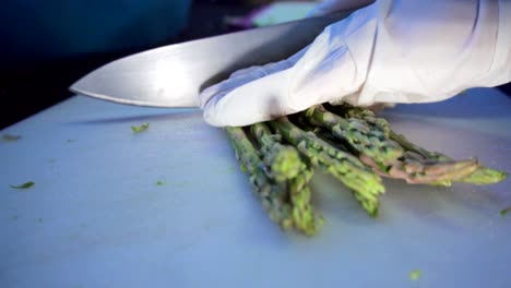 Hands-with-a-knife-cutting-asparagus