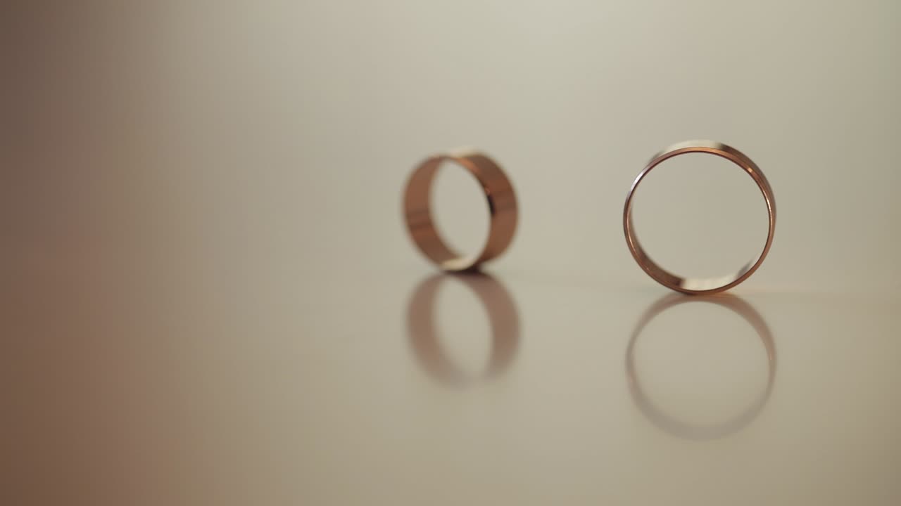 Wedding gold rings roll to each other. Close-up, macro shot