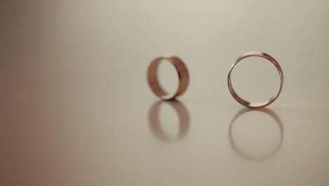 wedding gold rings roll to each other. close-up, macro shot